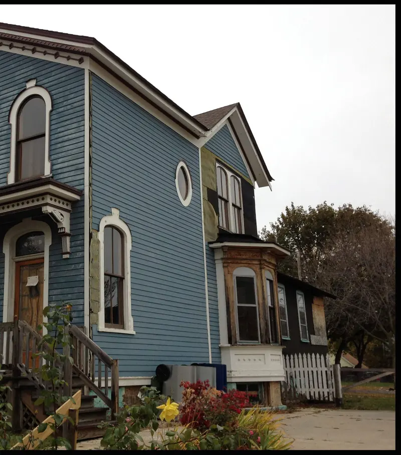 The Palmer house before: a two storey Italianate in blue paint with white arched window trim